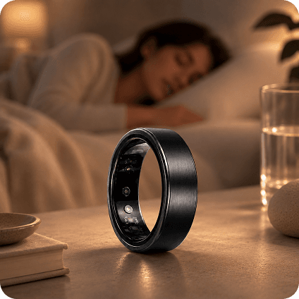 theera Midnight smart ring in deep graphite on a mossy rock with ferns